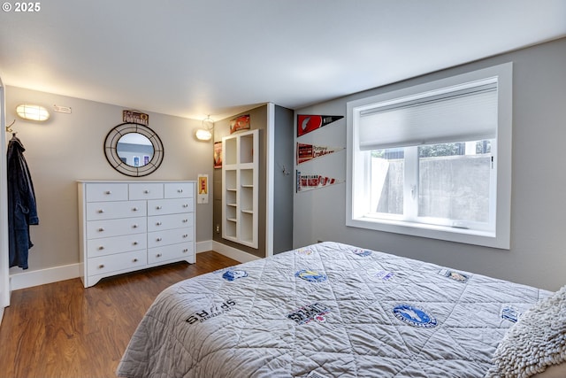 bedroom featuring baseboards and wood finished floors