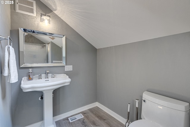 bathroom featuring visible vents, lofted ceiling, wood finished floors, and toilet