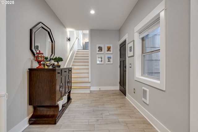 hall with visible vents, stairs, baseboards, light wood finished floors, and recessed lighting