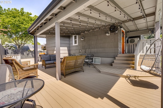 wooden terrace with an outdoor hangout area and outdoor dining space