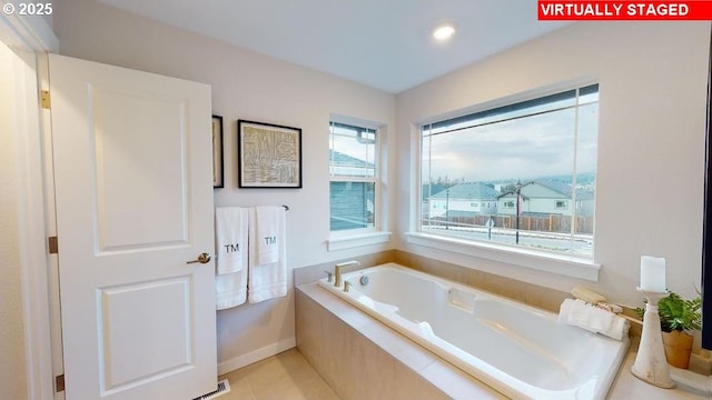 bathroom with tile patterned floors and a relaxing tiled tub