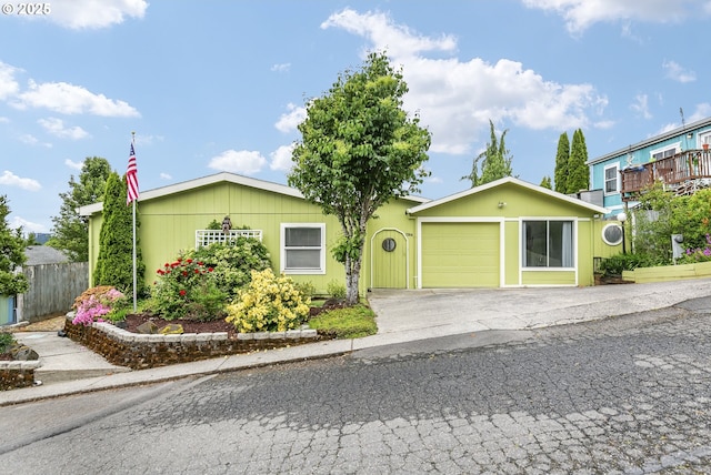 single story home with an attached garage, asphalt driveway, and fence