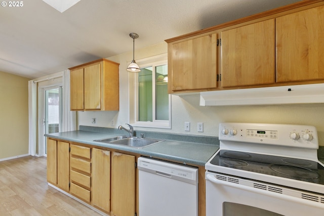 kitchen featuring white appliances, a sink, under cabinet range hood, light wood-type flooring, and hanging light fixtures