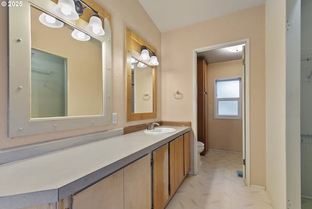 bathroom featuring vanity, toilet, tile patterned floors, and a spacious closet