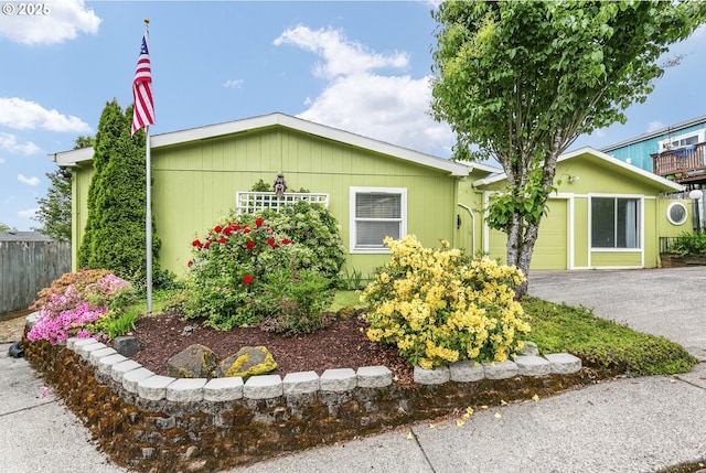 view of front of property featuring driveway, fence, and a garage
