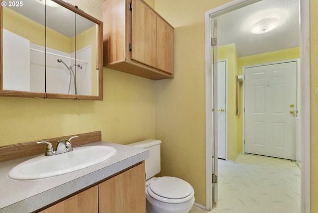 bathroom with toilet, vanity, and a shower