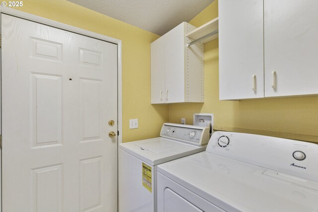 clothes washing area with separate washer and dryer, cabinet space, and a textured ceiling