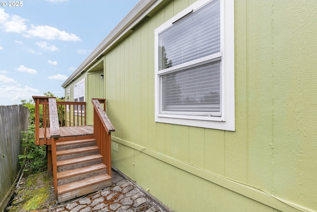 view of side of property with fence and a wooden deck