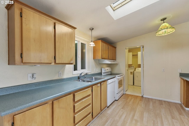 kitchen featuring washing machine and dryer, white appliances, a skylight, light wood finished floors, and a sink