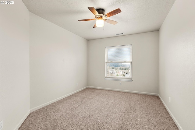 carpeted empty room featuring ceiling fan and a textured ceiling