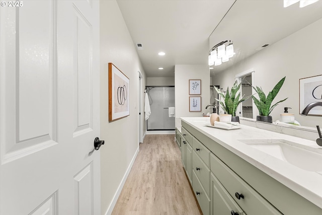 bathroom with vanity, hardwood / wood-style flooring, and a shower with door