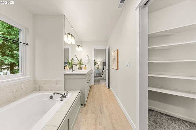 bathroom with a tub, vanity, and hardwood / wood-style flooring