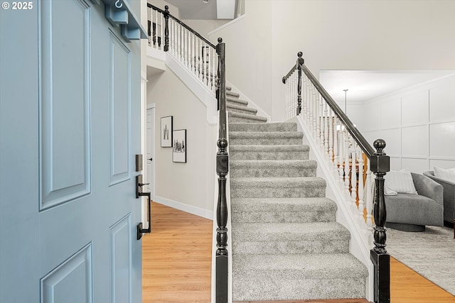 stairway featuring hardwood / wood-style flooring and crown molding