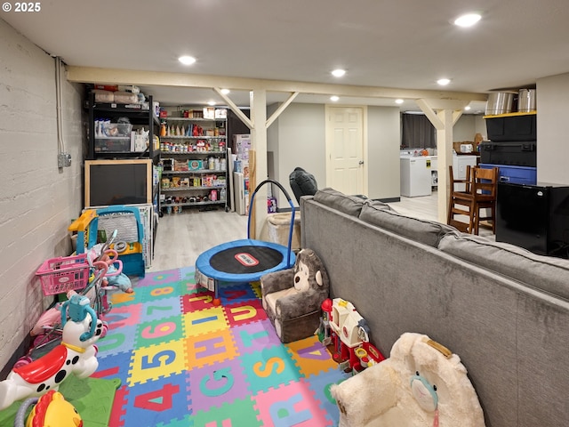 rec room with washer / clothes dryer and light hardwood / wood-style flooring