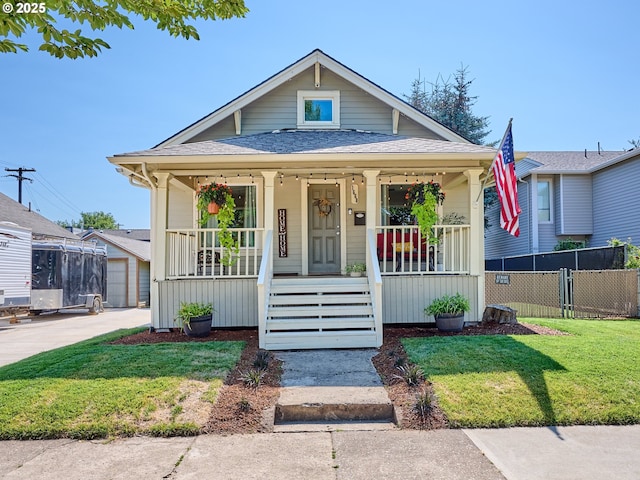 bungalow-style home with covered porch and a front lawn