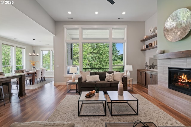 1825 NW Tanner Ct, Camas, WA 98607 - living area with wood finished floors, a tiled fireplace, baseboards, recessed lighting, and a chandelier
