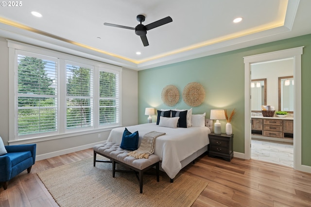 1825 NW Tanner Ct, Camas, WA 98607 - bedroom featuring a tray ceiling, wood finished floors, baseboards, recessed lighting, and ensuite bath