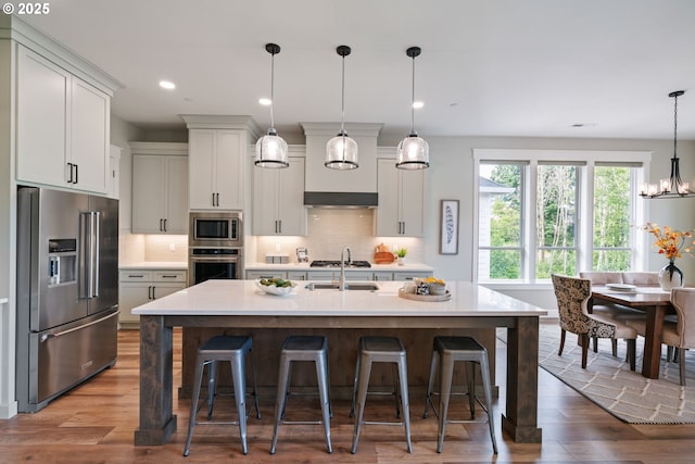 1825 NW Tanner Ct, Camas, WA 98607 - kitchen featuring stainless steel appliances, light countertops, a breakfast bar, decorative backsplash, and recessed lighting