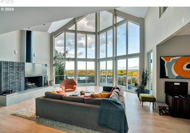 12508 NW Mountain View Rd, Portland, OR 97231 - living area with expansive windows, a fireplace with raised hearth, wood finished floors, and a towering ceiling