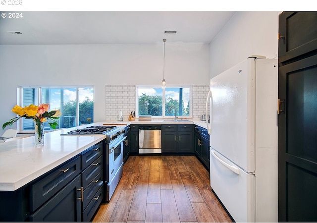 12508 NW Mountain View Rd, Portland, OR 97231 - kitchen featuring dark wood-style flooring, a sink, light countertops, stainless steel appliances, and tasteful backsplash