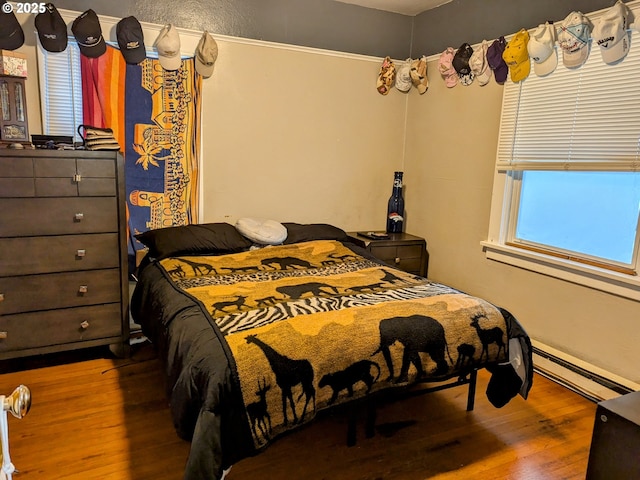 bedroom featuring a baseboard radiator and hardwood / wood-style floors