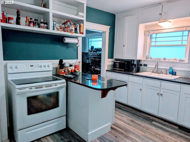 kitchen with hardwood / wood-style flooring, sink, white cabinets, and electric stove