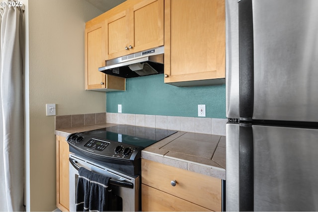 410 NW Uptown Ter Unit 3-B, Portland, OR 97210 - kitchen featuring freestanding refrigerator, under cabinet range hood, electric range oven, light brown cabinets, and tile counters
