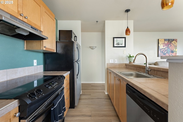 410 NW Uptown Ter Unit 3-B, Portland, OR 97210 - kitchen with black range with electric cooktop, dishwasher, under cabinet range hood, a sink, and light wood-style floors