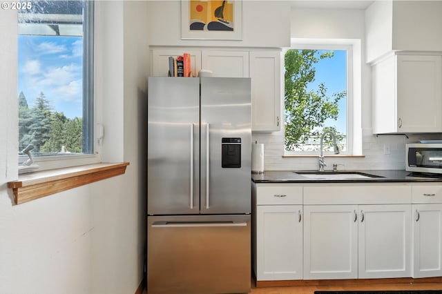 2024 SW Howards Way, Portland, OR 97201 - kitchen with appliances with stainless steel finishes, white cabinets, dark countertops, and tasteful backsplash