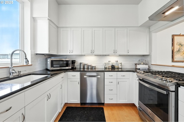 2024 SW Howards Way, Portland, OR 97201 - kitchen featuring appliances with stainless steel finishes, white cabinetry, and tasteful backsplash
