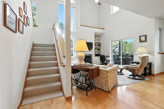 2024 SW Howards Way, Portland, OR 97201 - living area with wood finished floors, a high ceiling, a fireplace, stairway, and a ceiling fan