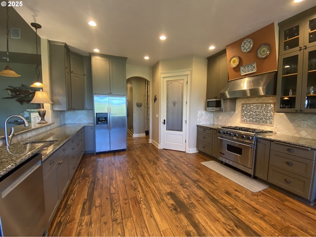 625 St Andrews Loop, Creswell, OR 97426 - kitchen with stainless steel appliances, a sink, arched walkways, extractor fan, and dark stone countertops