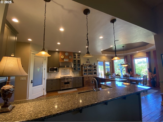 625 St Andrews Loop, Creswell, OR 97426 - kitchen with a sink, stainless steel appliances, wood finished floors, tasteful backsplash, and a kitchen bar
