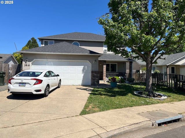 traditional-style house with concrete driveway, a front yard, an attached garage, and fence
