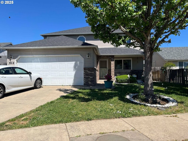 view of front facade with an attached garage, fence, concrete driveway, a front yard, and brick siding