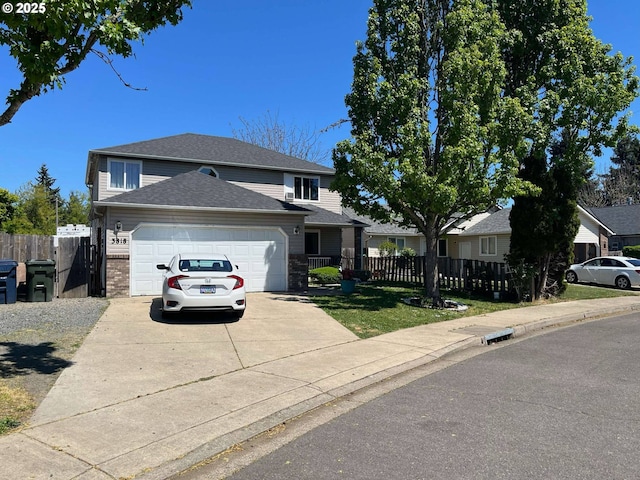 traditional-style house with concrete driveway, an attached garage, a shingled roof, and fence