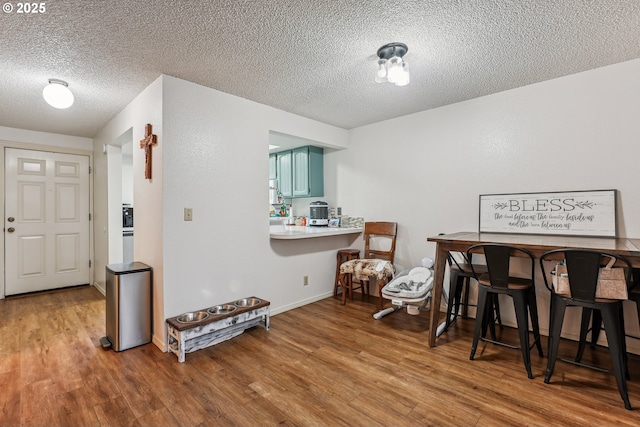 dining space featuring hardwood / wood-style flooring and a textured ceiling