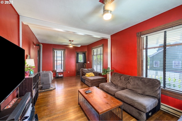 103 NW 4th St, Willamina, OR 97396 - living area with baseboard heating, ceiling fan, a wood stove, and wood finished floors