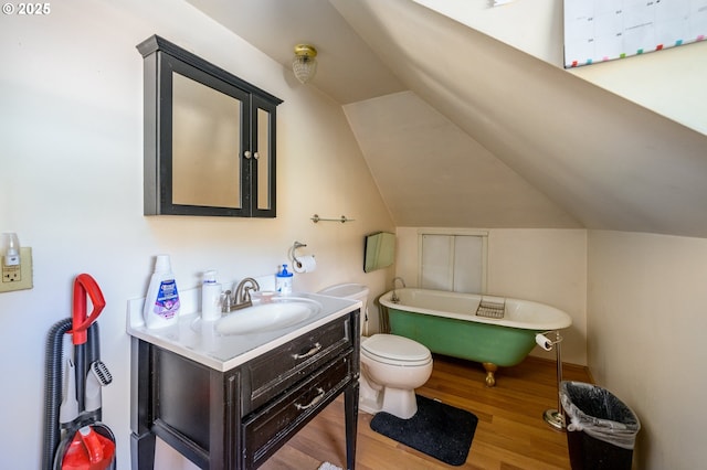 103 NW 4th St, Willamina, OR 97396 - bathroom with a freestanding bath, wood finished floors, vanity, toilet, and lofted ceiling