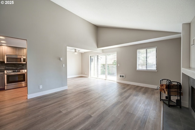 56 Galen St, Lake Oswego, OR 97035 - unfurnished living room featuring high vaulted ceiling, wood finished floors, a fireplace, baseboards, and ceiling fan