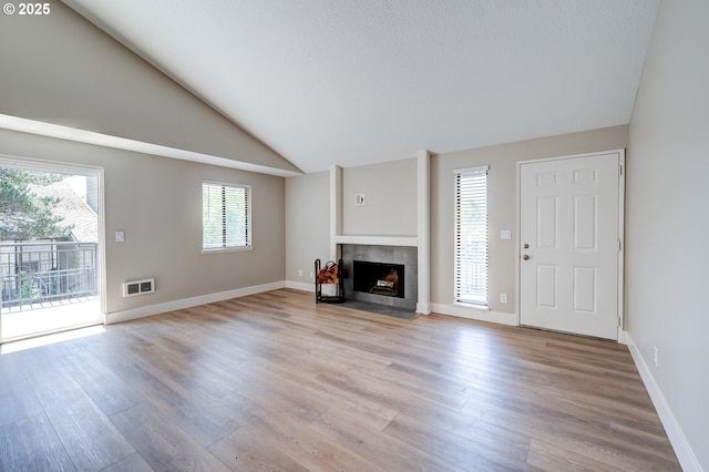 56 Galen St, Lake Oswego, OR 97035 - unfurnished living room with light wood-type flooring, healthy amount of natural light, a fireplace, lofted ceiling, and baseboards