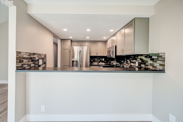56 Galen St, Lake Oswego, OR 97035 - kitchen featuring appliances with stainless steel finishes, decorative backsplash, gray cabinetry, recessed lighting, and dark countertops