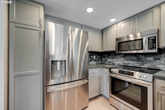 56 Galen St, Lake Oswego, OR 97035 - kitchen featuring appliances with stainless steel finishes, gray cabinets, dark countertops, tasteful backsplash, and recessed lighting