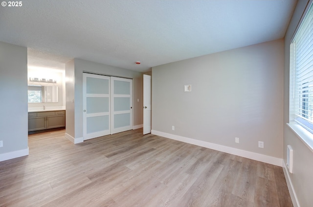56 Galen St, Lake Oswego, OR 97035 - unfurnished bedroom featuring light wood-type flooring, multiple windows, a sink, and a textured ceiling