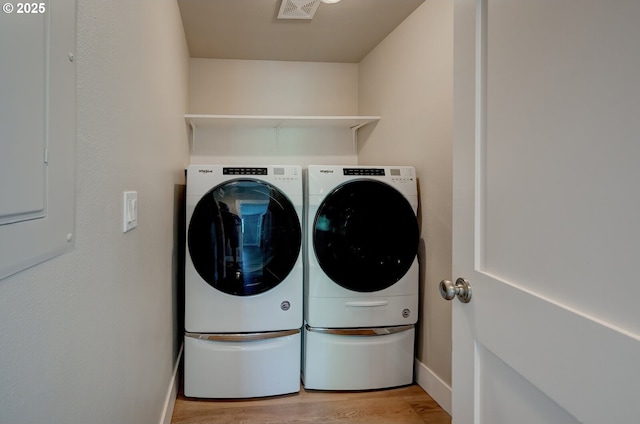 56 Galen St, Lake Oswego, OR 97035 - laundry room with washer and dryer, light wood-style flooring, baseboards, and electric panel