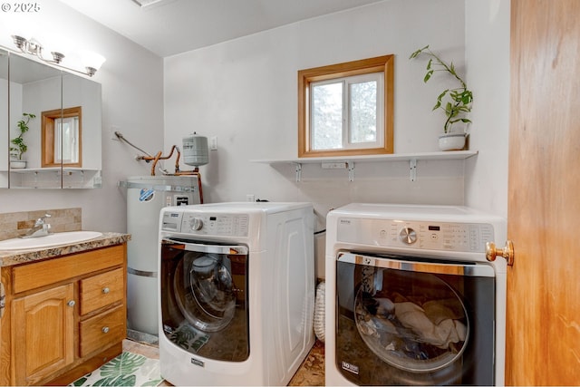 laundry room with a sink, cabinet space, electric water heater, and washer and clothes dryer