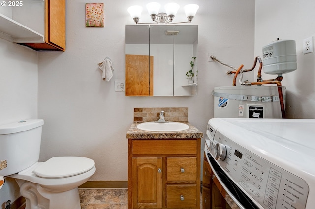 bathroom with washing machine and clothes dryer, tasteful backsplash, baseboards, toilet, and water heater