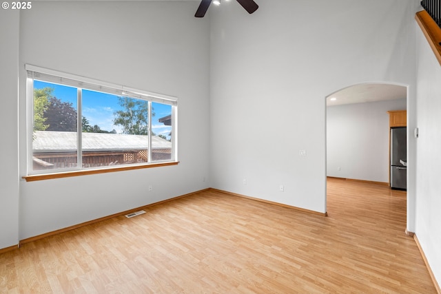651 NE Anderson Rd, Gresham, OR 97030 - empty room featuring a high ceiling, arched walkways, ceiling fan, and light wood finished floors