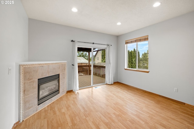 651 NE Anderson Rd, Gresham, OR 97030 - unfurnished living room featuring wood finished floors, a tiled fireplace, and recessed lighting