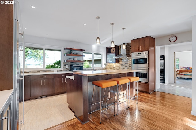 34926 SW Johnson School Rd, Cornelius, OR 97113 - kitchen featuring appliances with stainless steel finishes, wall chimney exhaust hood, light countertops, open shelves, and recessed lighting